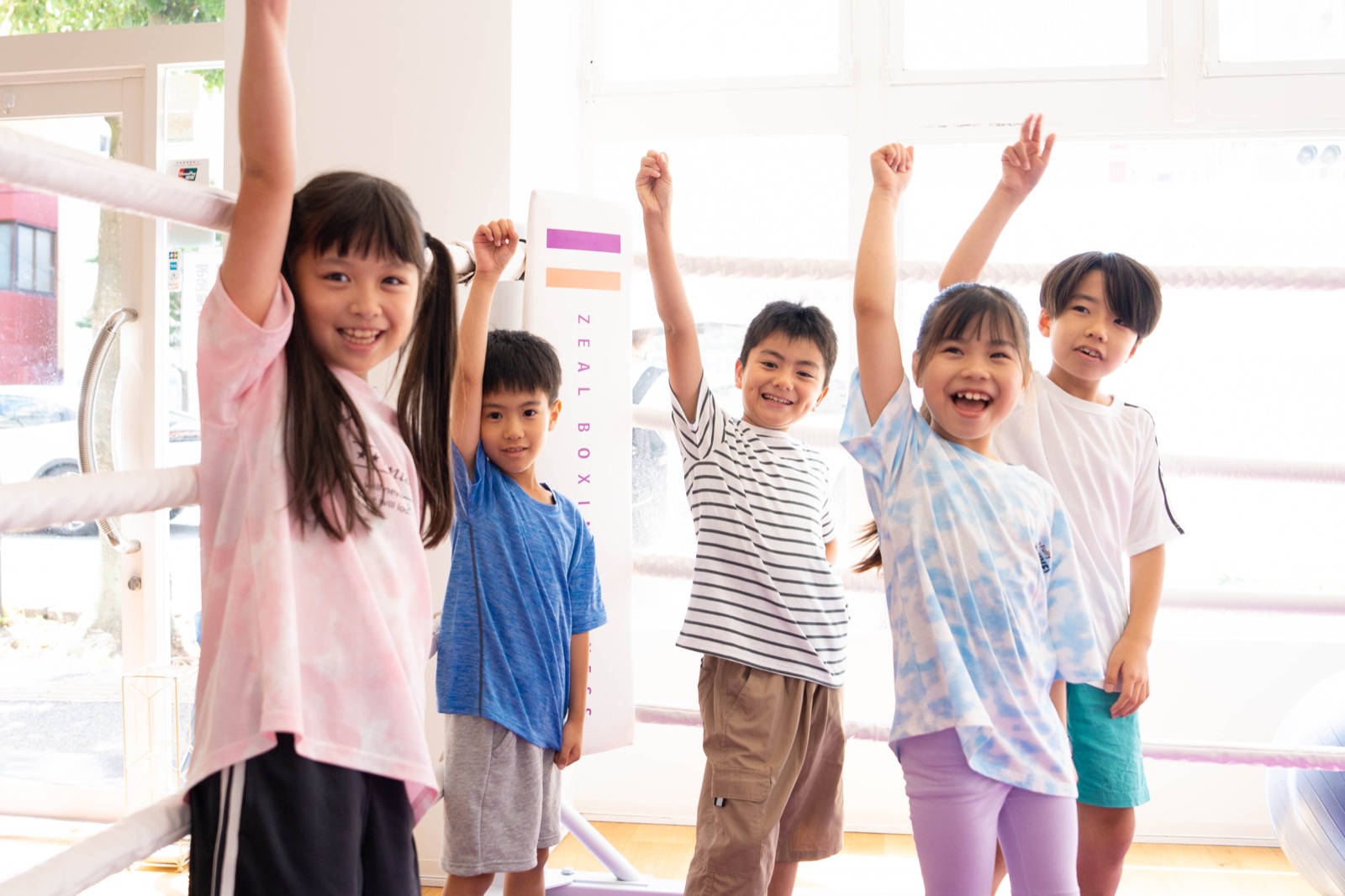 西新エリアからも通えるEnglish Fight Kidsのジムで、コーチと一緒に明るくボールトレーニングを行う子どもたち